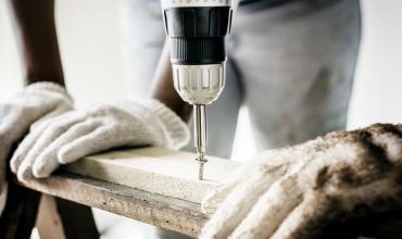 North Carolina Program Has Kept 15,000 Homeowners Safely in Their Homes A worker using a power drill