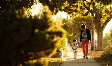 Woodlane Street Apartments Offers Affordable Homes for Granite Falls Families woman and child walking together on a sidewalk