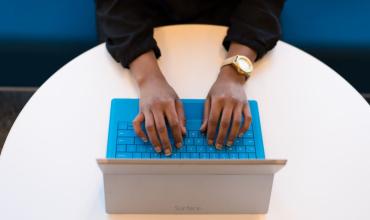 Person sitting with their hands on a keyboard