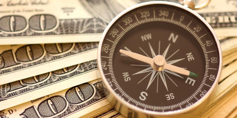 How to Prioritize Your Finances a compass on top of money