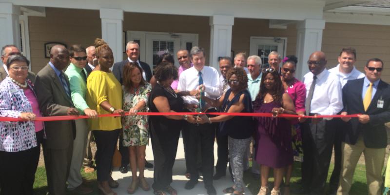 a ribbon cutting ceremony on a front porch